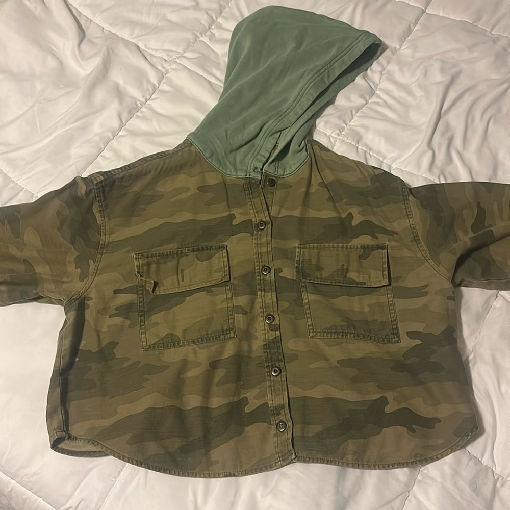 An camo cropped jacket with a hood. Two front pockets, comfy and lightweight.
